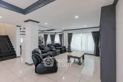 Spacious modern living room with sleek black leather sofas and elegant decor