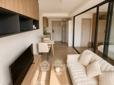 Modern open-plan living room with cozy sofa and stylish kitchen area in a contemporary apartment.