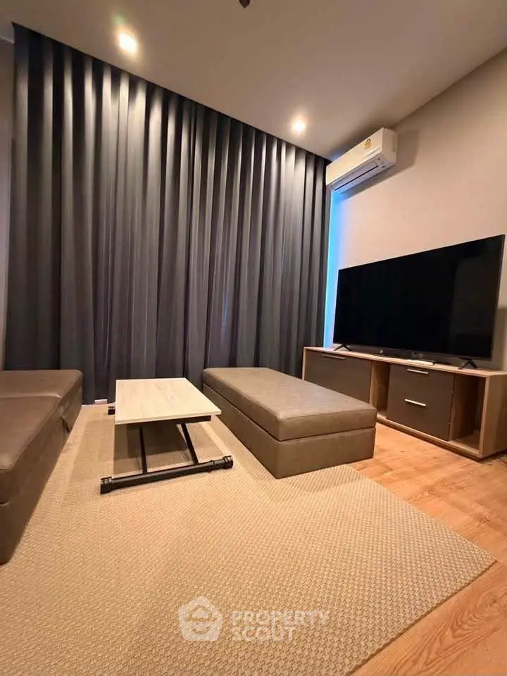 Modern living room with sleek furniture and large TV, perfect for relaxation.