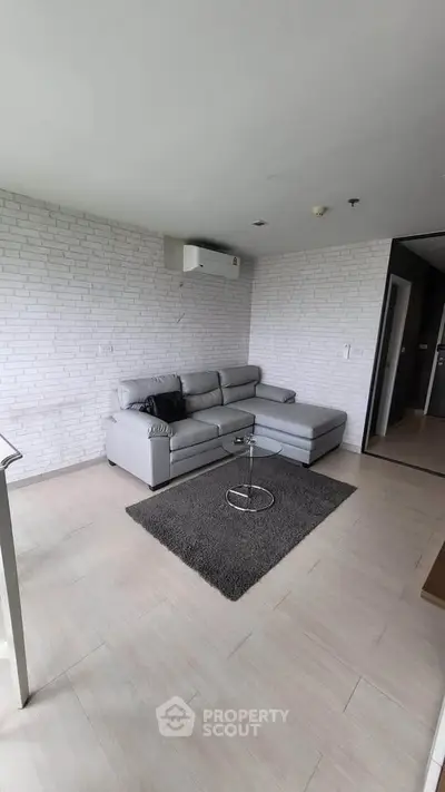 Modern living room with sleek gray sofa and minimalist decor in a stylish apartment.