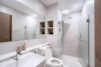 Modern bathroom with glass shower and sleek fixtures in a contemporary home.