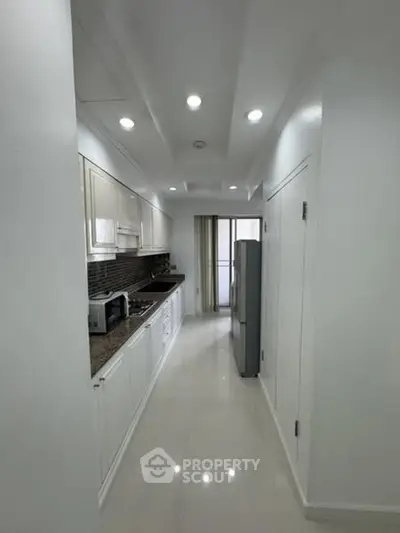 Sleek modern kitchen with white cabinetry and stainless steel appliances