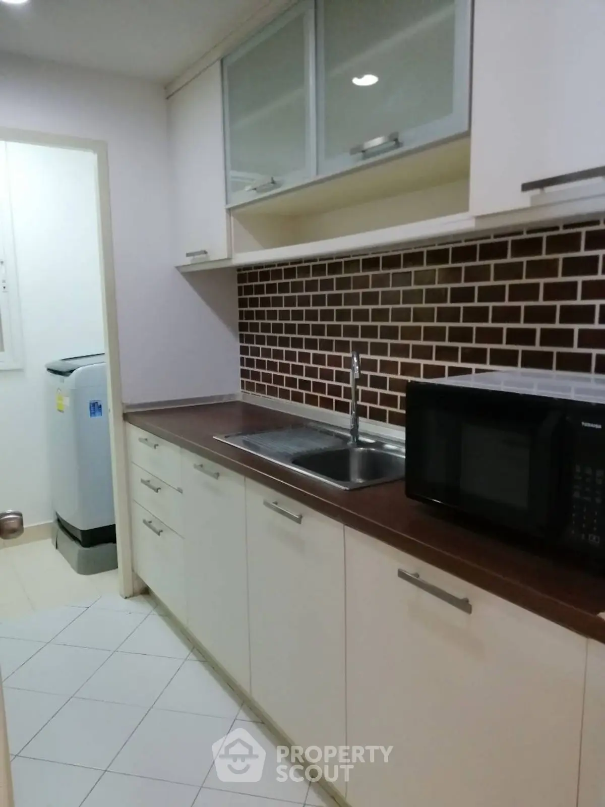 Modern kitchen with sleek cabinetry and brick backsplash
