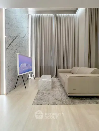 Modern living room with sleek marble accents and stylish furniture, featuring a contemporary TV setup.