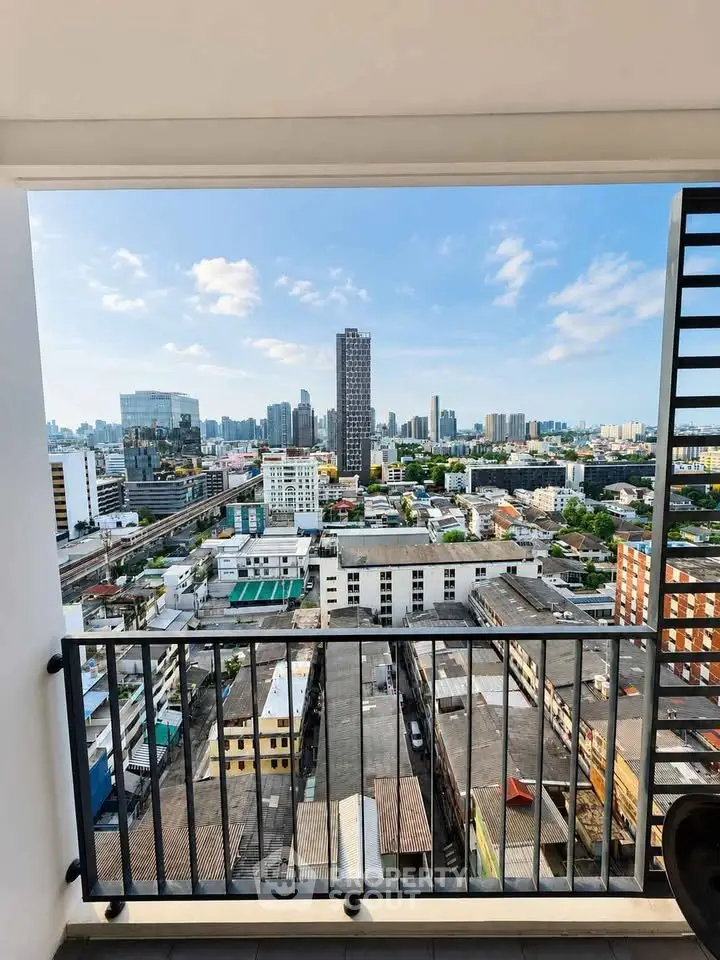 Stunning cityscape view from a high-rise balcony, showcasing urban skyline and clear blue skies.