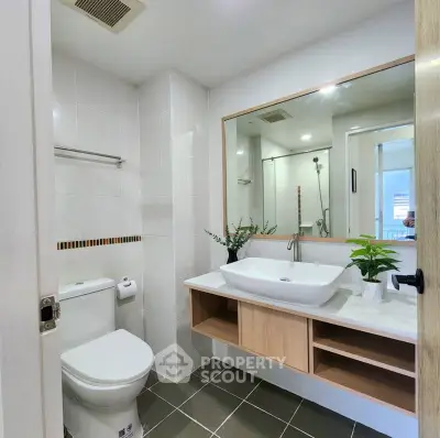 Modern bathroom with sleek fixtures and large mirror in a stylish apartment.