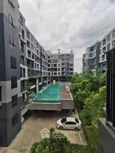 Modern apartment building with lush greenery and parking area