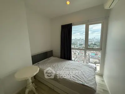 Cozy bedroom with city view and natural light, featuring a comfortable bed and small table.