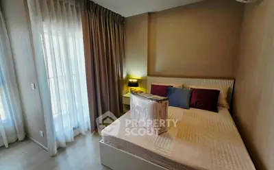 Cozy bedroom with modern decor and natural light from large window.