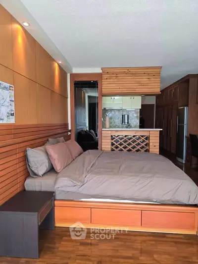 Spacious bedroom with modern wooden decor and open kitchen layout