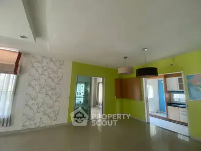 Spacious living room with vibrant walls and modern lighting in a stylish home.