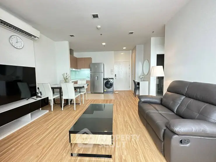 Modern living room with sleek furniture and open kitchen layout in a stylish apartment.