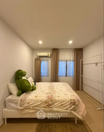 Cozy bedroom with plush bedding and ample natural light, perfect for relaxation.