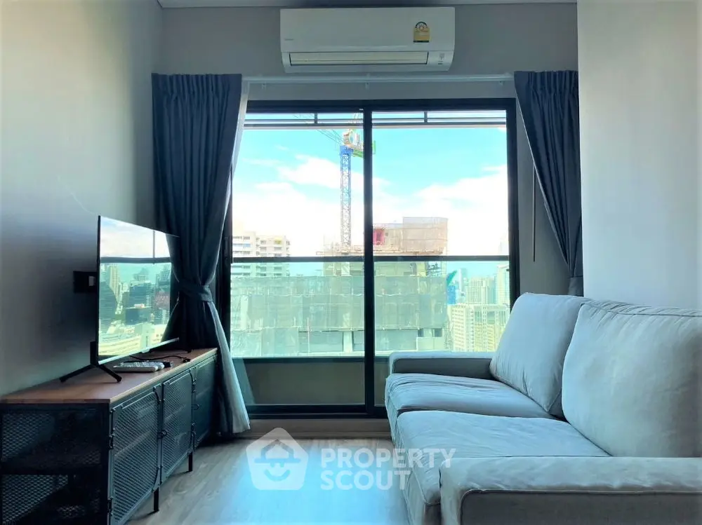 Modern living room with city view, large window, and cozy sofa