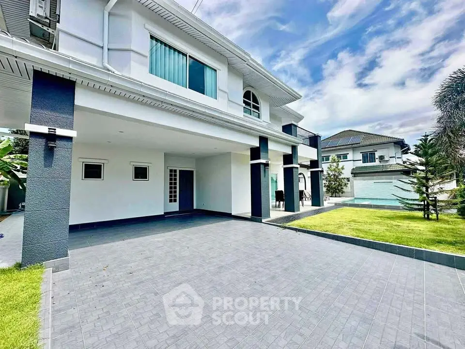 Elegant modern house with spacious driveway and lush green lawn