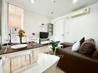 Modern living room with sleek furniture and open layout, featuring a cozy dining area and stylish decor.