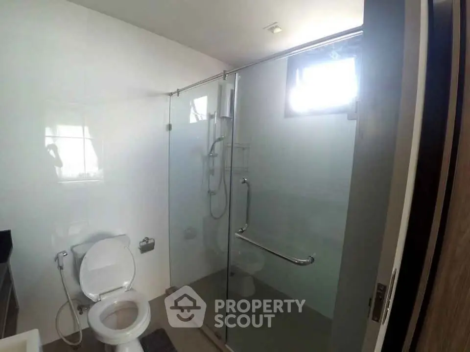Modern bathroom with glass shower enclosure and sleek fixtures