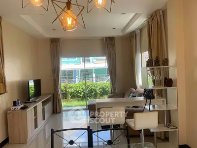 Modern living room with stylish lighting, large windows, and cozy seating area.