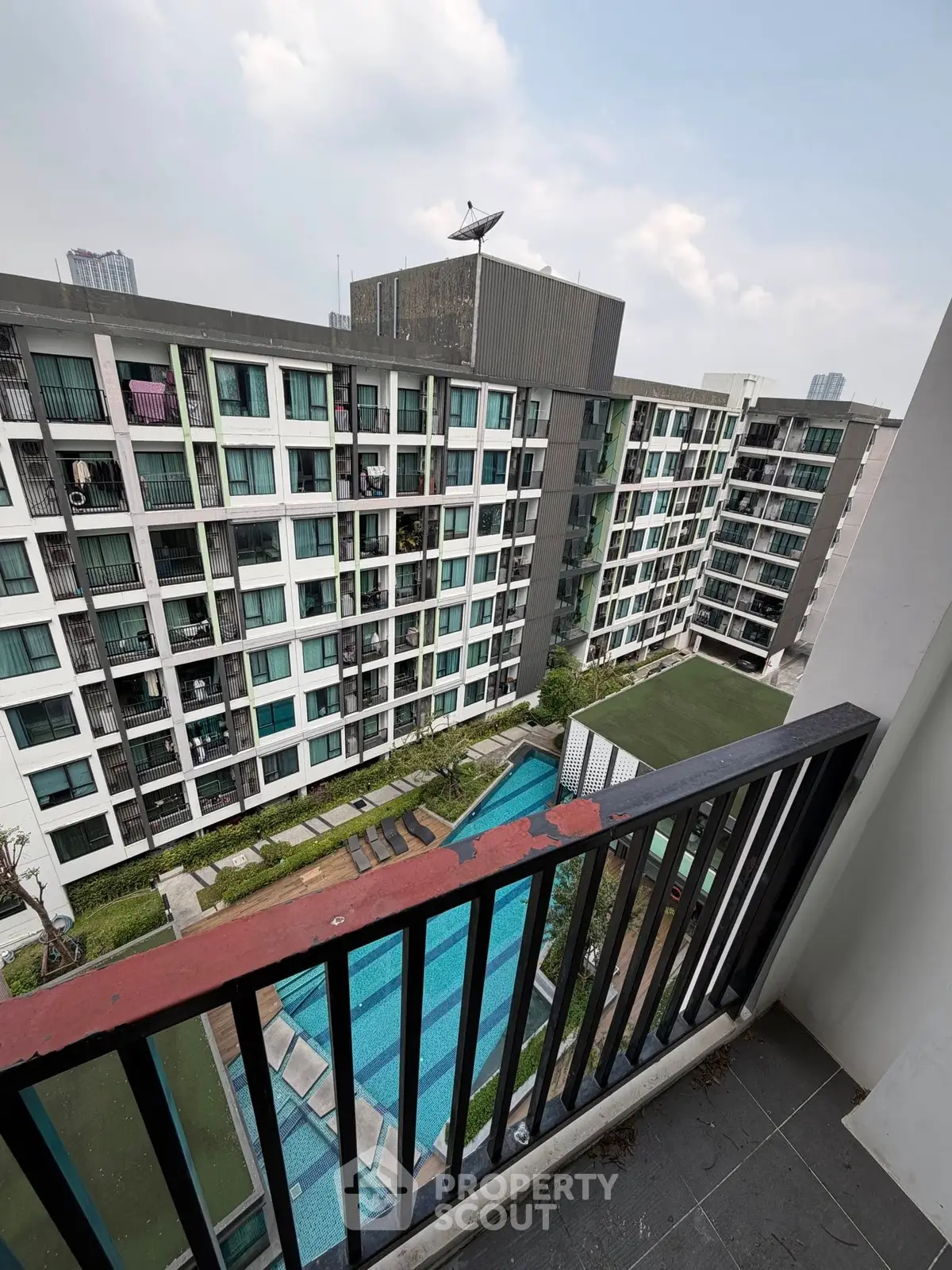 Modern apartment building with pool view from balcony, ideal urban living.