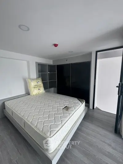 Modern bedroom with sleek design and spacious layout, featuring a comfortable mattress and ample storage.