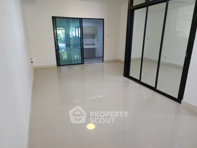Spacious modern living room with sliding glass doors and glossy tile flooring