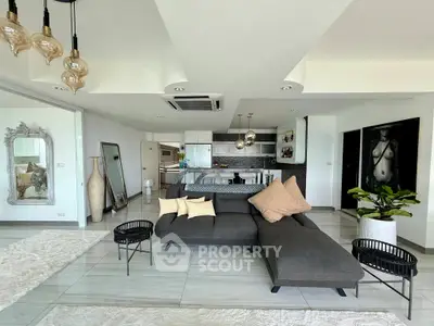 Spacious modern living room with open kitchen, stylish decor, and elegant lighting in a luxury apartment.