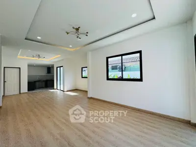 Spacious open-plan living room with modern kitchen and elegant lighting