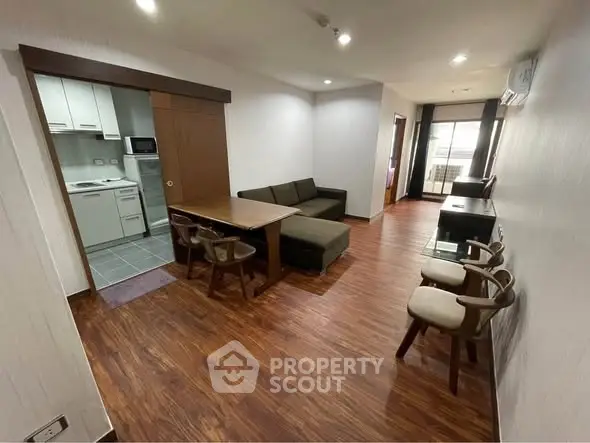 Spacious living room with modern furniture and open kitchen layout in a stylish apartment.