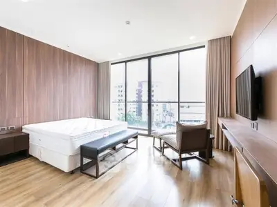Spacious modern bedroom with large windows and stylish furnishings.