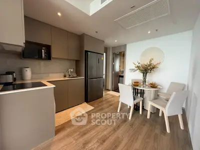 Modern kitchen with dining area featuring sleek cabinetry and stylish decor