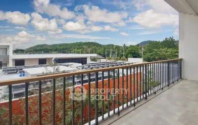 Spacious balcony with scenic view of lush greenery and modern architecture.