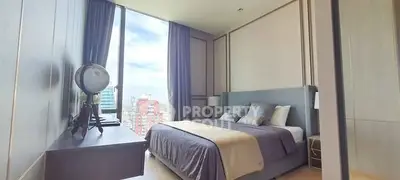 Luxurious bedroom with city view and elegant decor in high-rise apartment.