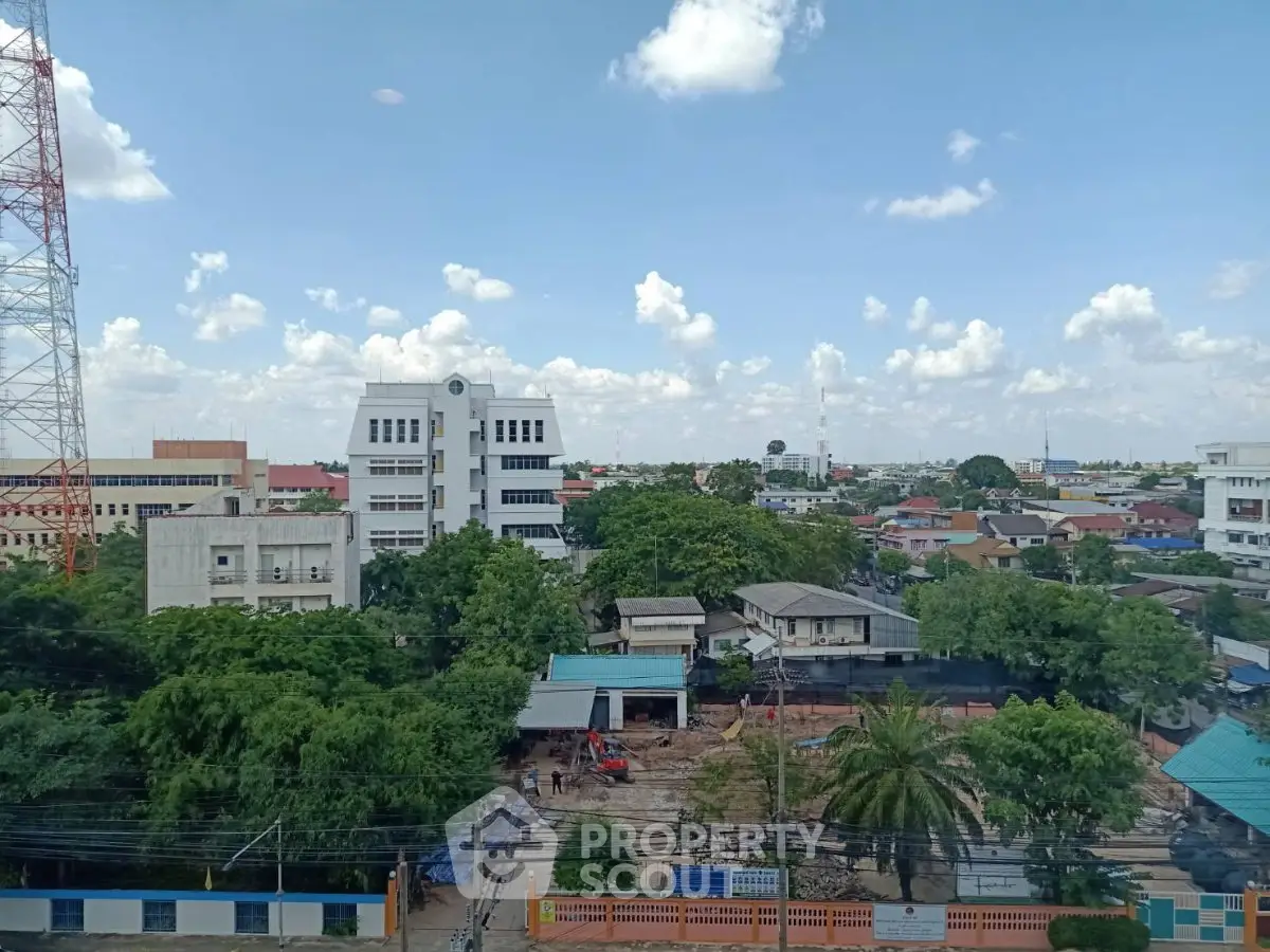 Scenic cityscape view with lush greenery and urban buildings under a clear blue sky.