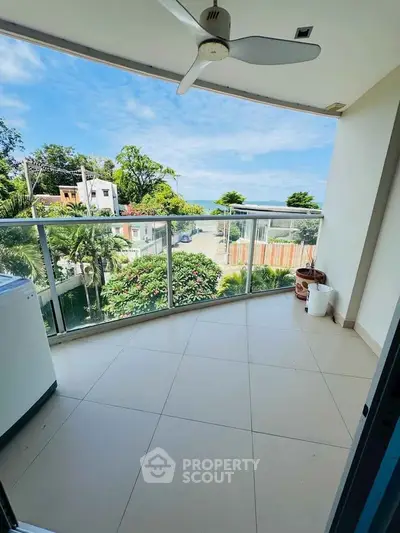 Spacious balcony with scenic view and ceiling fan, perfect for relaxation.