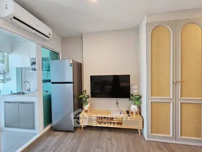 Modern living room with sleek TV setup and stylish kitchen view