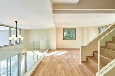 Spacious modern living room with wooden flooring and elegant staircase