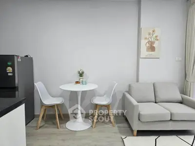 Modern living room with stylish furniture and minimalist decor, featuring a cozy sofa and dining area.