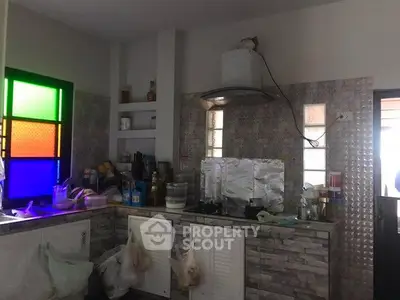 Cozy kitchen with colorful stained glass window and modern gas stove