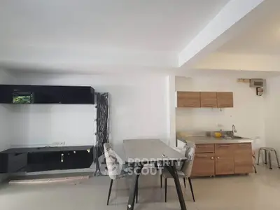 Modern kitchen with sleek cabinets and dining area in open layout apartment