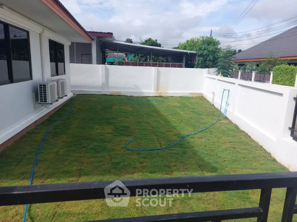 Spacious backyard with fresh green lawn and modern fencing in suburban home.