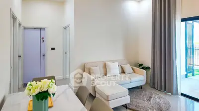 Modern living room with cozy sofa and elegant decor, featuring large windows and stylish dining area.
