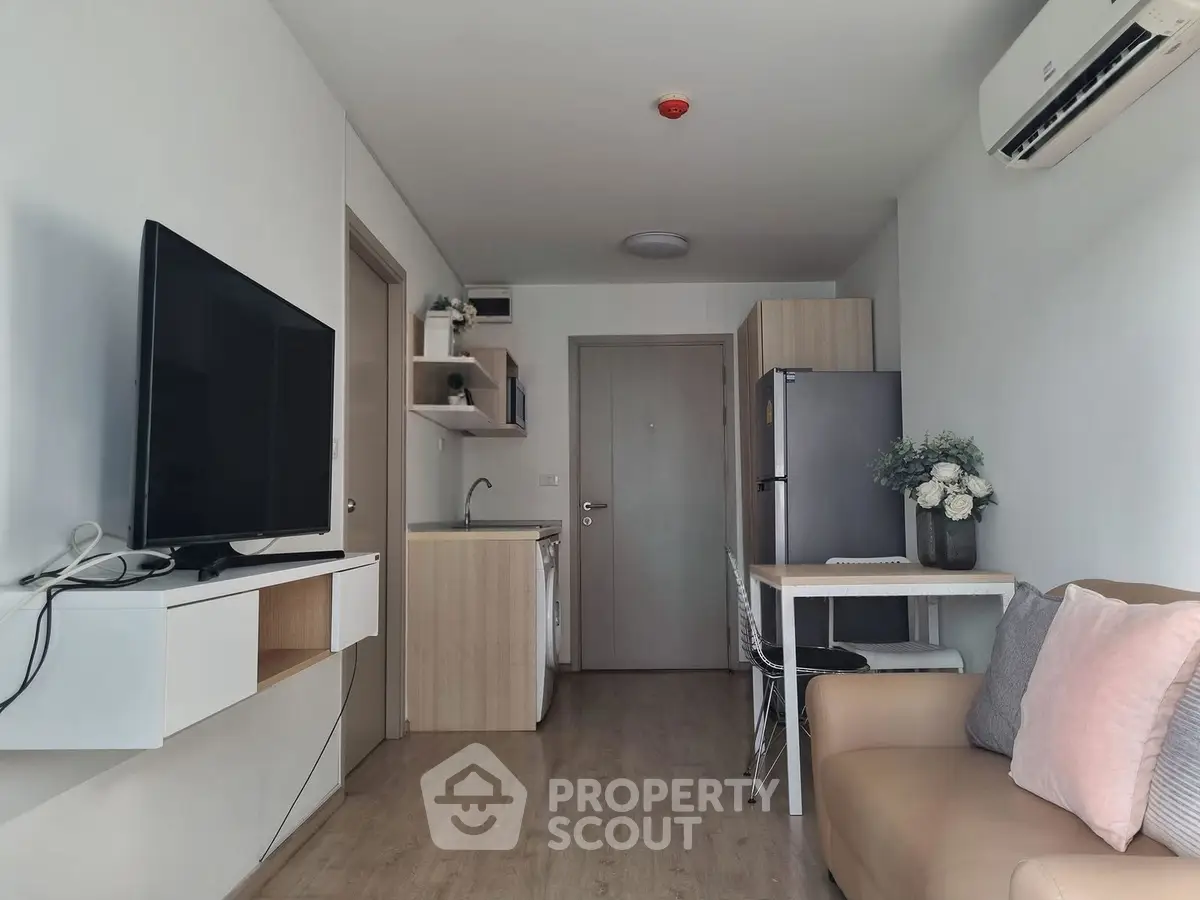 Modern living room with sleek furniture and open kitchen layout in a cozy apartment.