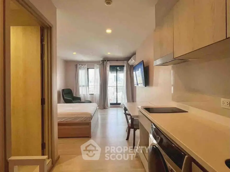 Modern studio apartment with open layout, featuring a cozy bedroom and compact kitchen area.