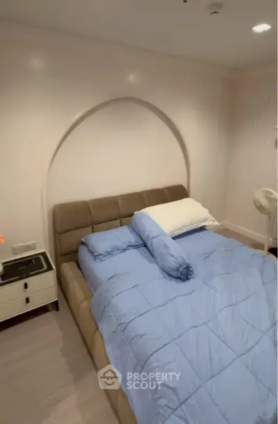 Cozy bedroom with modern design and comfortable bedding in a stylish real estate property.