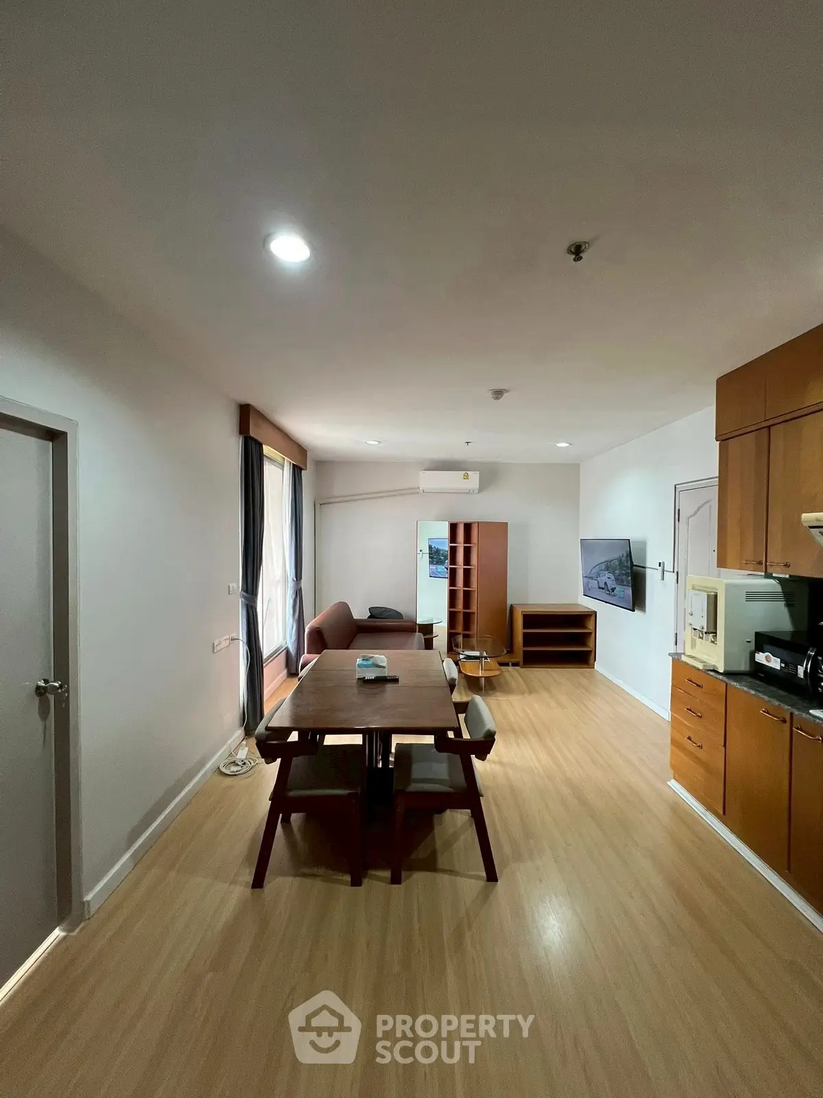 Spacious modern living room with open kitchen and wooden flooring