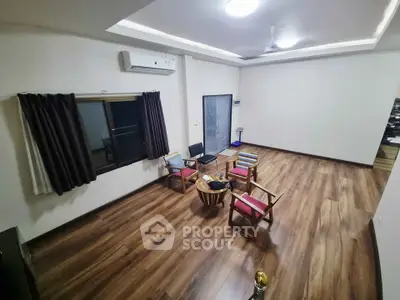 Spacious living room with wooden flooring and modern furniture, perfect for relaxation and entertainment.