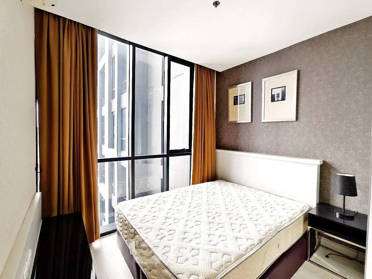 Modern bedroom with large window and stylish decor in urban apartment