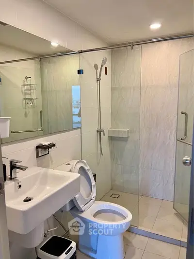 Modern bathroom with glass shower and sleek fixtures in a contemporary apartment.