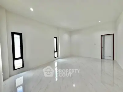 Spacious empty room with glossy white tile flooring and modern windows