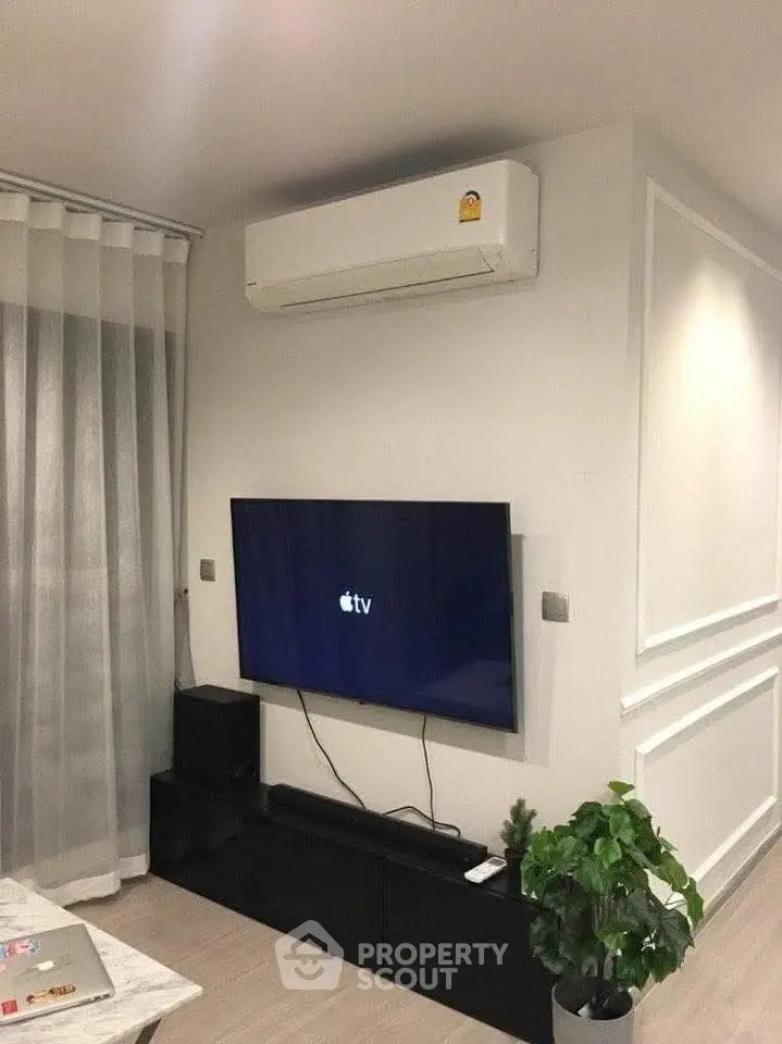 Modern living room with wall-mounted TV and air conditioning unit.